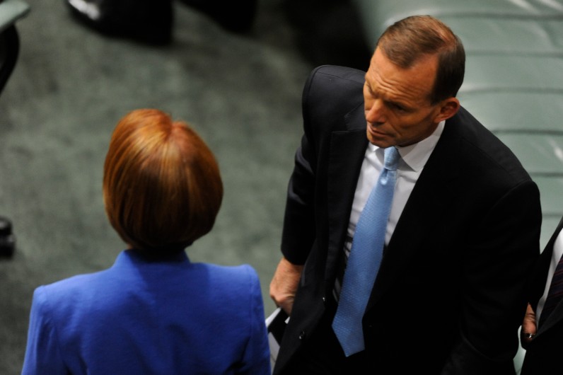 The Leader of the Opposition Tony Abbott walks past Prime Minister Julia Gillard on that day in October 2012