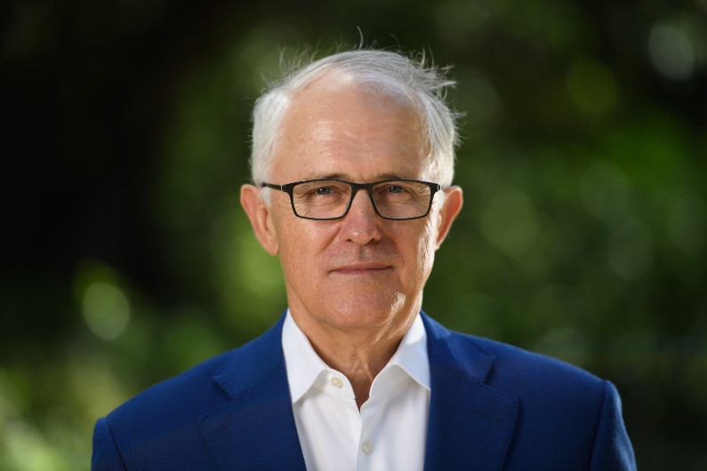 Former prime minister Malcolm Turnbull portrait shot standing in sunlit graden