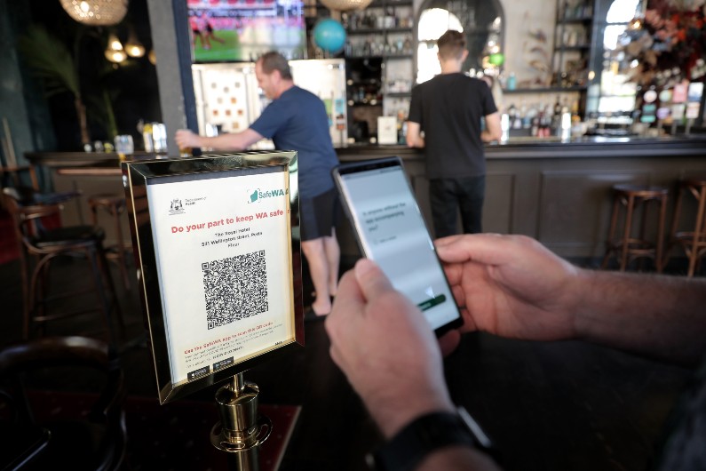 Customers are seen scanning into a pub using the SafeWA app in Perth