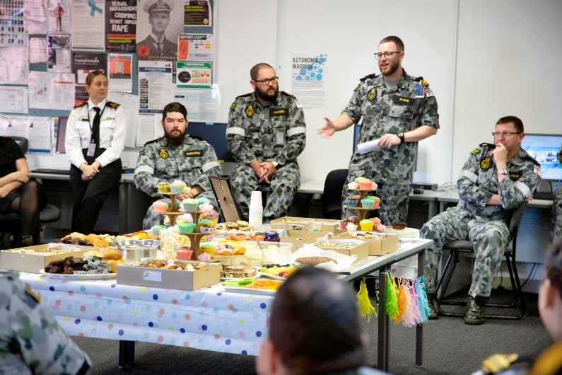 Lieutenant Kyle Irvine speaks with HMAS Stirling ship's company during a morning tea for the International Day Against Homophobia, Biphobia, Interphobia and Transphobia (IDAHOBIT) at Stirling in Western Australia.