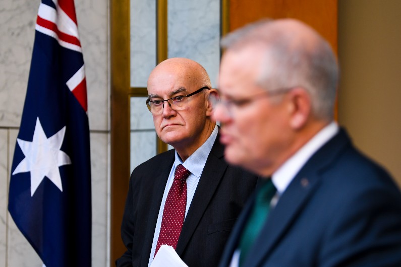 TGA head Professor John Skerritt listens to Scott Morrison. (AAP Image/Lukas Coch)