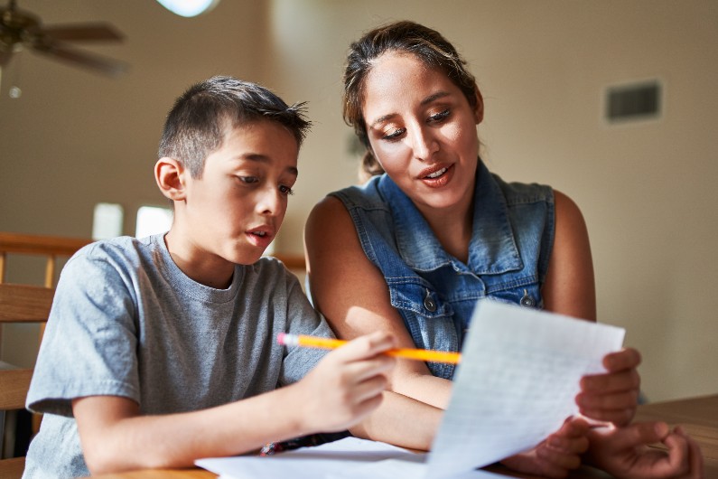 a woman tutoring a young teenage boy