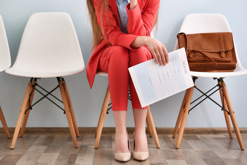 woman in red suit sitting on a white cahair