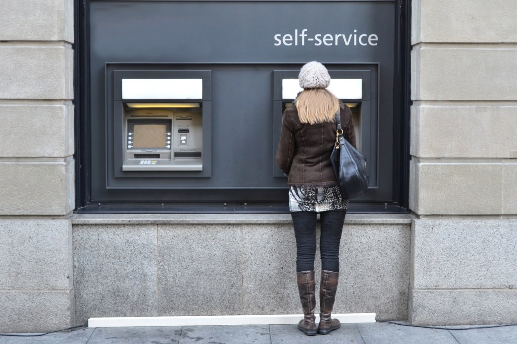 Woman standing at ATM