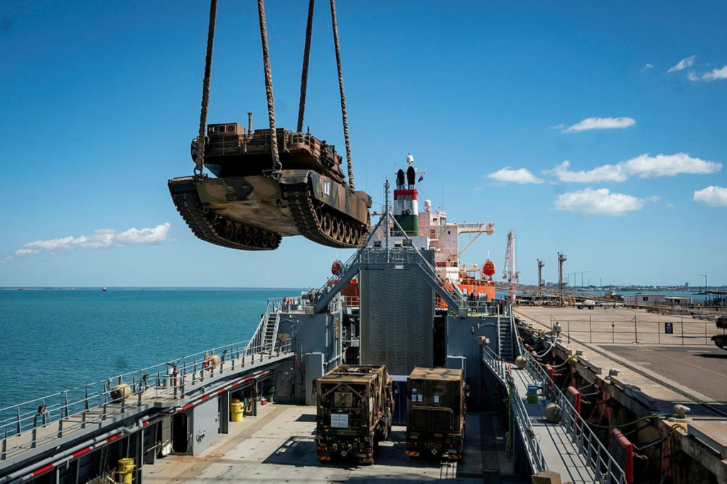 Abrams tank being craned ontp a military boat